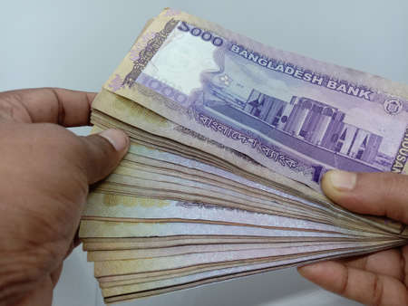 bangladeshi bank note and coin on white backgroundの写真素材