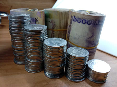 bangladeshi bank note and coin on white backgroundの写真素材