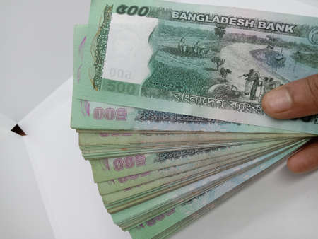 bangladeshi bank note and coin on white backgroundの写真素材