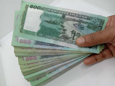 bangladeshi bank note and coin on white backgroundの写真素材