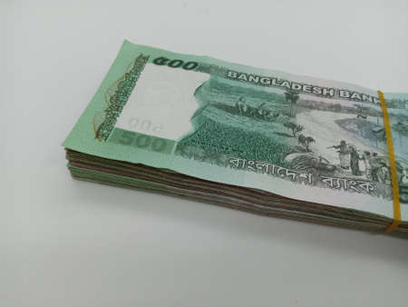 bangladeshi bank note and coin on white backgroundの写真素材