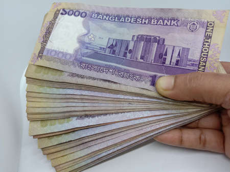 bangladeshi bank note and coin on white backgroundの写真素材