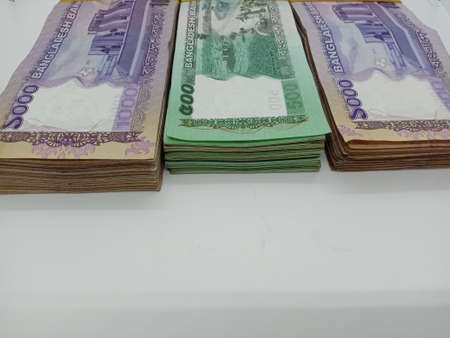 bangladeshi bank note and coin on white backgroundの写真素材