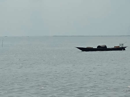 black colored wooden fishing boat on riverの写真素材