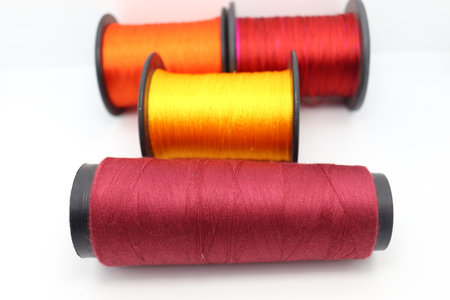 multiple colored yarn reel closeup on white background for craft