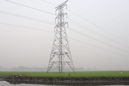 high voltage electric pillar closeup on green field for current supply