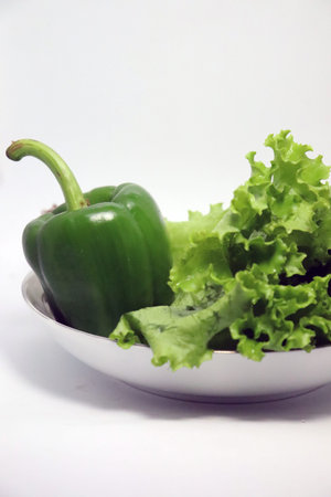 tasty and healthy green colored capsicum and lettuce leaf on bowlの写真素材