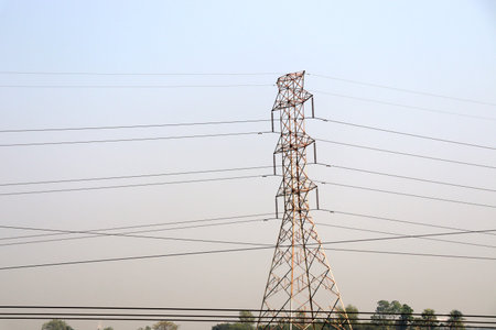 high voltage electric pillar closeup on green field for current supply