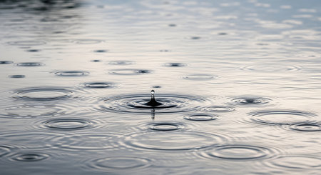 Falling drops of water. Splash effect after collision a falling drops with water Surfaceの素材
