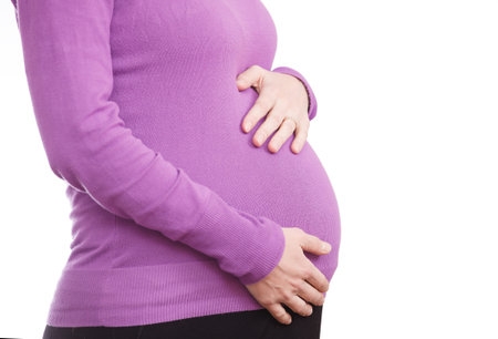 Pregnant woman touching her belly, isolated on white background