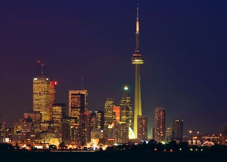 Brightly lit skyscrapers of Toronto's financial district with the CN Tower and a silhouette of the waterfrontの写真素材