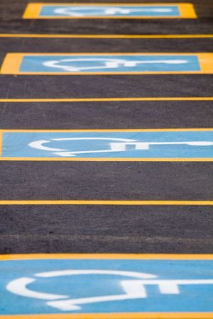 Row of parking spaces with a handicapped signの写真素材