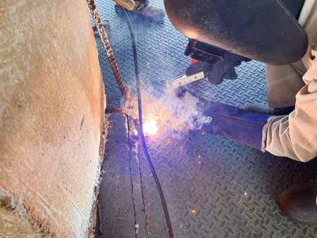 Welder at work on a construction site. Welding of steel