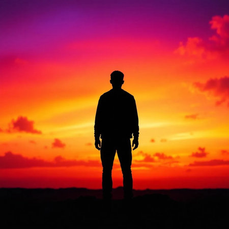 Silhouette of a man standing in front of a beautiful sunsetの素材