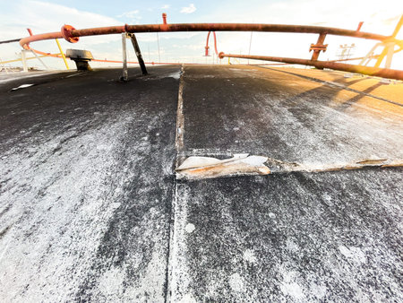 Cracked concrete floor in construction site with sunlight and lens flare.