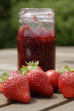 A number of strawberries in front of a jar of home-made jam, portrait formatの写真素材