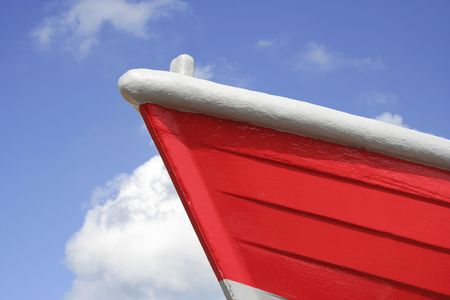 Front of a bright red boat against a lovely blue sky, landscape formatの写真素材