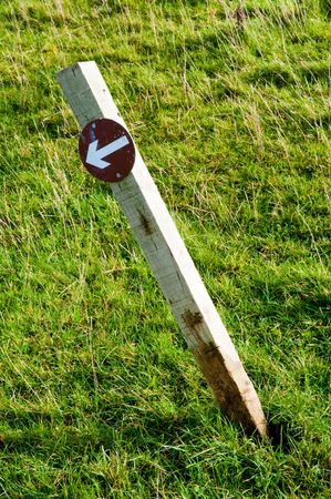 Crooked arrow sign in Scottish fieldの写真素材