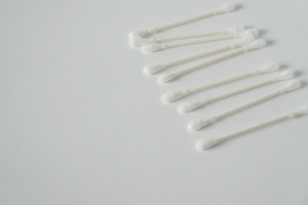 Q tip, or cotton bud swab top view on horizontal white background with blank empty space for copy or text; Features best health care hygiene practices to clean ear.の素材 [FY310124366278]