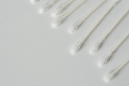 Q tip, or cotton bud swab top view on horizontal white background with blank empty space for copy or text; Features best health care hygiene practices to clean ear.の写真素材