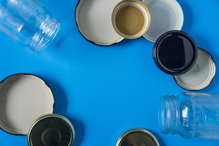 Recycling glass jar lids for reuse of single use items; Zero no waste recycle program campaigns; Recyclable concept on blank empty copyspace, text room space for copy on horizontal blue background.の写真素材