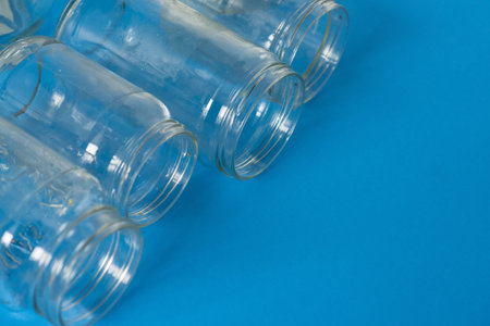 4 several glass jars on an isolated blue background with copyspace or blank empty room space for...
