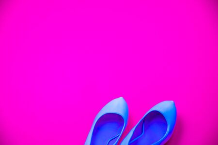 Blue high heeled shoes on pink purple background - top view concept - blank empty room space for text or copy. Classic fashion. Heels pointing right.の写真素材