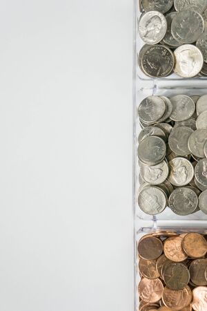 Isolated organized loose coin change on right side, white background, blank empty room space for copy or text on left. Financial organization money concept, top view of pennies, nickels, and quarters.の写真素材