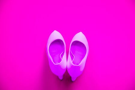 Pink high heeled shoes on pink purple background - top view concept - blank empty room space for text or copy. Suitable for holidays like Valentine's. Classic dress up fashion. Heels pointing upの写真素材