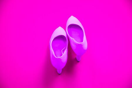 Pink high heeled shoes on pink purple background - top view concept - blank empty room space for text or copy. Suitable for holidays like Valentine's. Classic dress up fashion. Heels pointing upの写真素材
