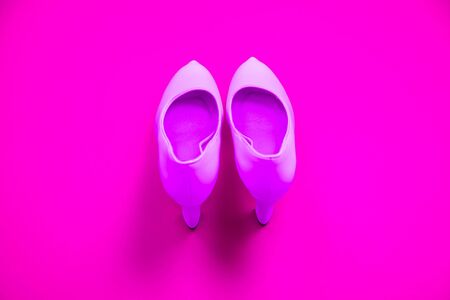 Pink high heeled shoes on pink purple background - top view concept - blank empty room space for text or copy. Suitable for holidays like Valentine's. Classic dress up fashion. Heels pointing upの写真素材