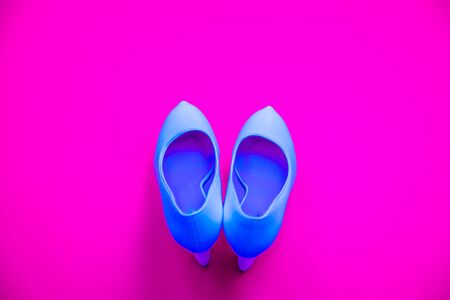 Blue high heeled shoes on pink purple background - top view concept - blank empty room space for text or copy. Classic dress up fashion. Heels pointing up. Dressed up.の写真素材