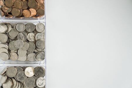 Isolated organized loose coin change on left side, white background, blank empty room space for copy or text on right. Financial organization money concept, top view of pennies, nickels, and quarters.の写真素材