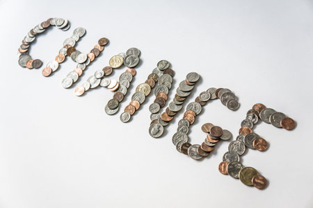Coins isolated on solid white background spelling the word Change from loose coin change. Blank...
