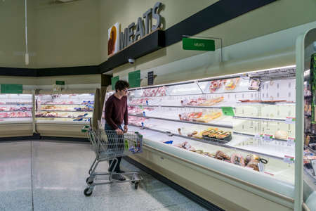 Atlanta, GA / USA - 04/02/20: A guy checking out the meat section at Publix where most poultry/ chicken is out of stock due to high demand and stockpile hoarding.のeditorial素材