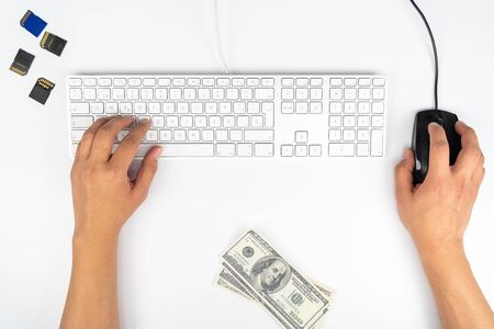 Working at home with laptop men writing a blog. Typing on a keyboard. Programmer or computer hacker, Dollars, online commerceのeditorial素材