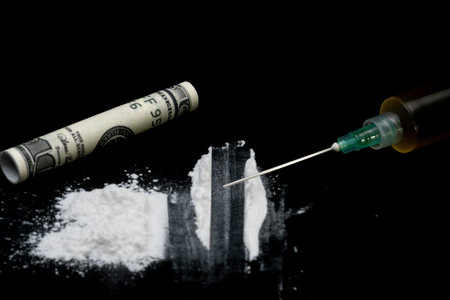 Cocaine or other illegal drugs, white powder, syringe, isolated on black glossy background