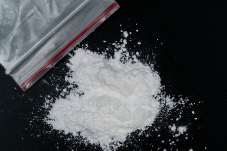 Cocaine or other illegal drugs, white powder, syringe, isolated on black glossy backgroundの写真素材