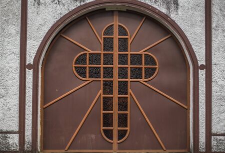 Catholic or Christian cross at the door of an abandoned church.の写真素材