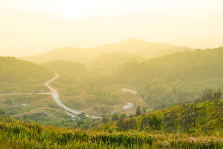 The road on mountains at sunrise on foggy day 