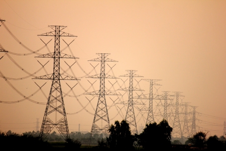 Electricity pylons and lines at sunset near Bangkok, Thailandの写真素材