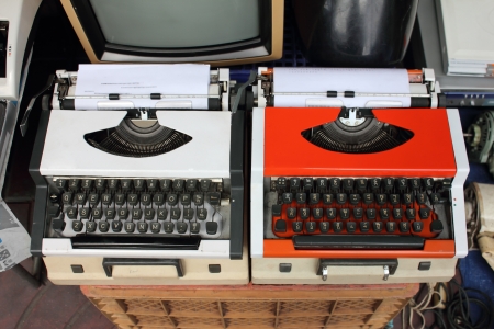 White and orange vintage typewriters at a used marketの写真素材
