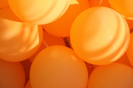 orange plastic balloons and ray of lightの写真素材