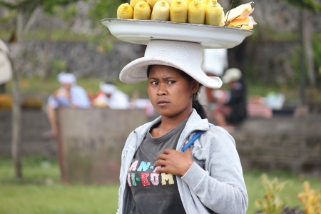 2012 in Bali, BALI â OCTOBER 17: Unidentified village women carry offerings of food baskets on their heads and pilgrims coming out from Besakih temple in October 17, Indonesia.のeditorial素材