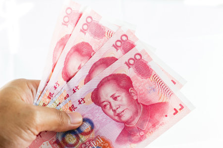 chinese yuan currency in hand on white backgroundの写真素材