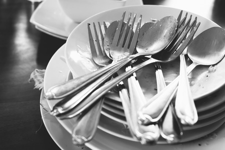 pile of dirty dishes in black and whiteの写真素材