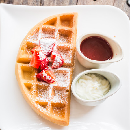 food backgroud -waffle with strawberry sauce on wooden tableの写真素材