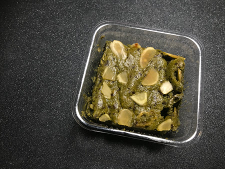 Green tea with nuts in a plastic container on a black backgroundの写真素材