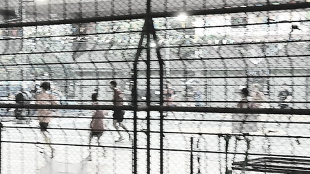 Blurred Football Match Through Metal Net Viewの写真素材