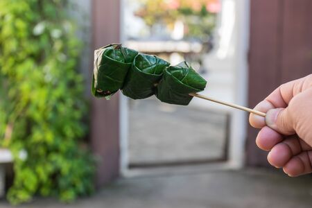 A royal leaf wrap appetizer, Miang kham. It is a hors dâoeuvre of wild betel leaves enfold bursts of roasted peanuts and coconut, the dry shrimp, shallots, ginger, lime, bitter orange and chilies.の写真素材